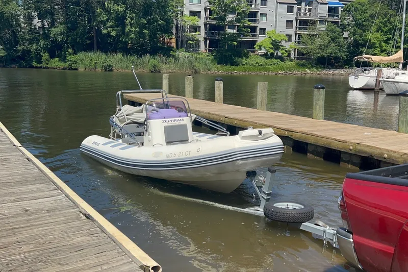 Slide: The Image of 2019 Brig Navigator 485 boat being launched from a trailer at a dock. - 23