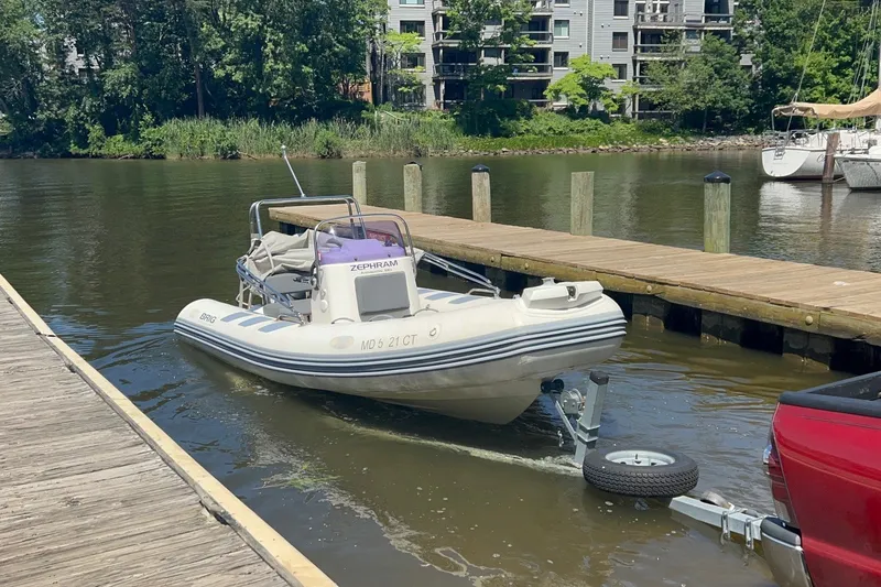 Slide: The Image of 2019 Brig Navigator 485 boat being launched from a trailer at a dock. - 24