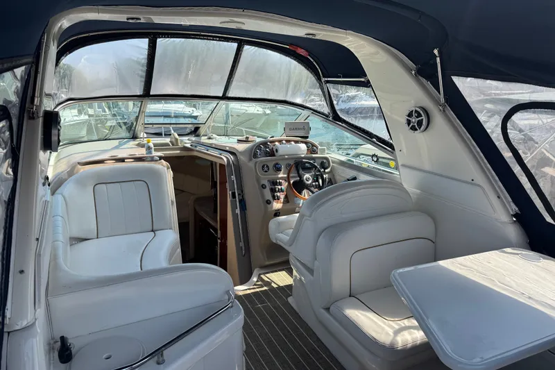 Slide: The Image of Interior of 2001 Sea Ray 290 Sundancer boat with white seating and navigation controls. - 5