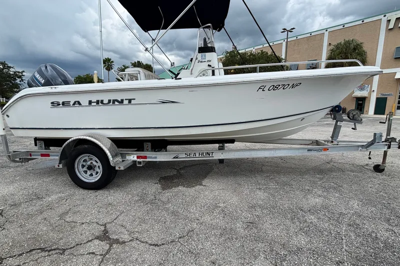 Slide: The Image of 2006 Sea Hunt Triton 186 boat on trailer, parked outdoors under cloudy sky. - 3