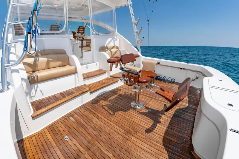 Slide: The Image of The image shows the teak deck of a 2018 Viking Sport Tower boat with seating and a fishing chair. - 9