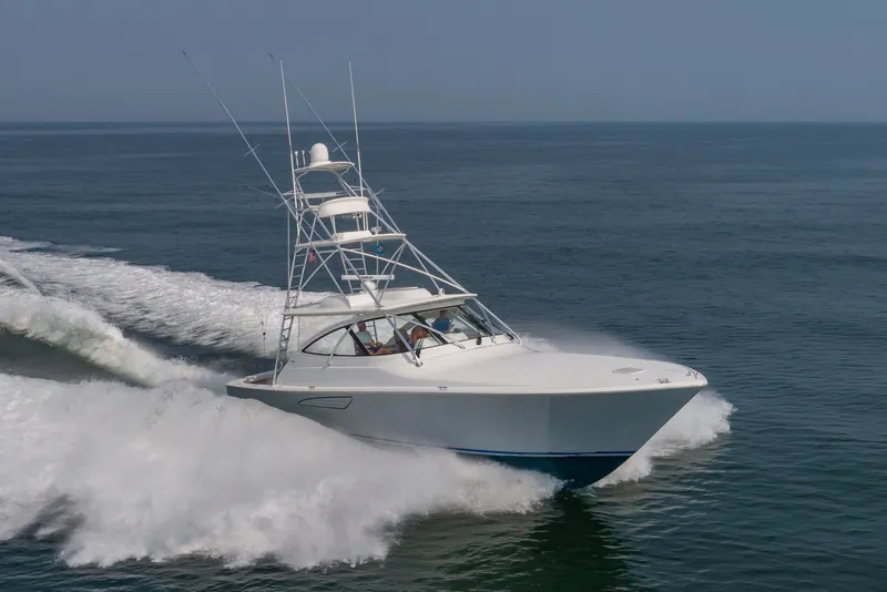 Slide: The Image of A 2018 Viking Sport Tower boat speeds across the water, featuring a prominent tower and antennas. - 1