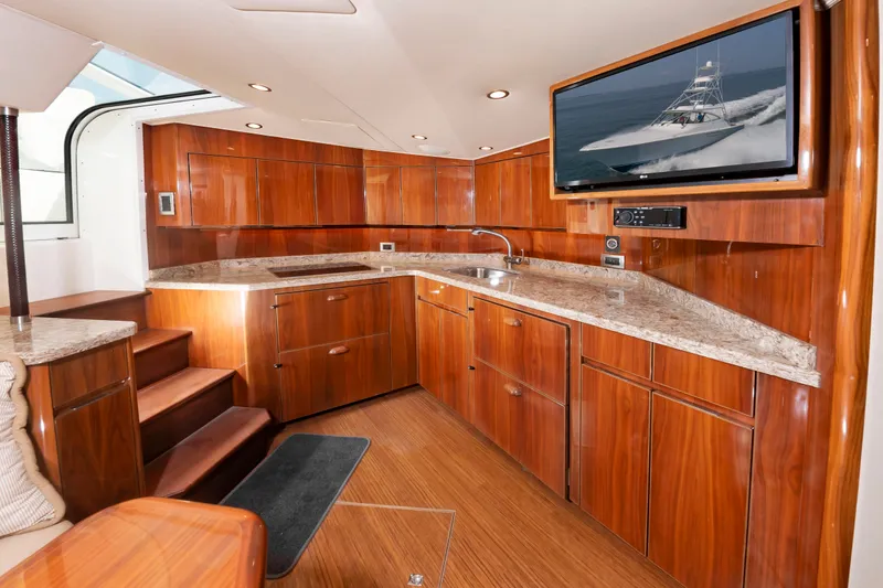 Slide: The Image of Interior view of a luxury yacht kitchen with wooden cabinets, granite countertops, and a TV. - 28