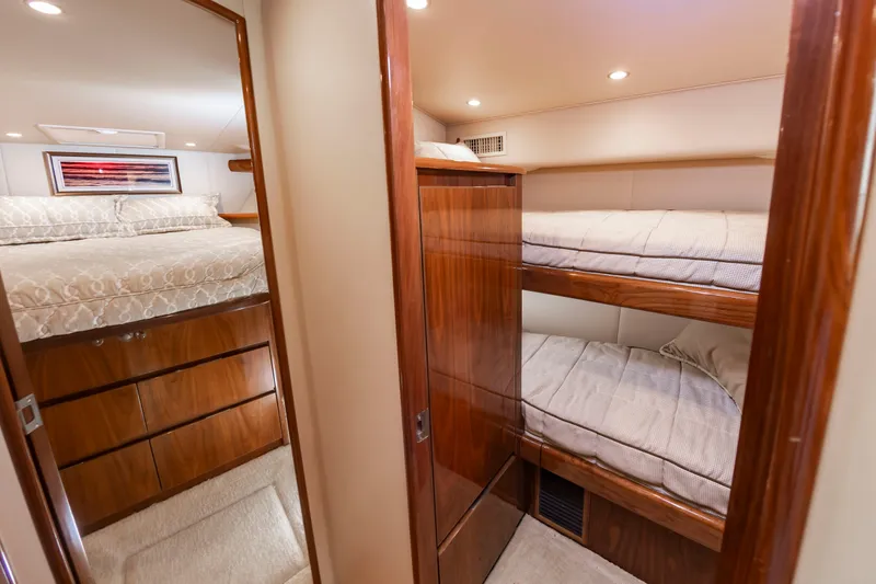 Slide: The Image of The 2018 Viking Sport Tower cabin features bunk beds and a mirror, surrounded by wood paneling. - 32