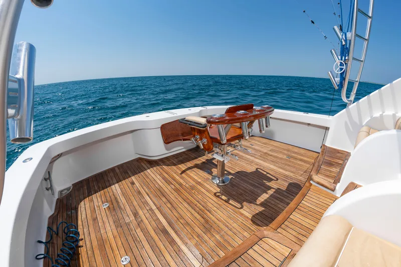 Slide: The Image of The image shows the deck of a 2018 Viking Sport Tower yacht with wood paneling and fishing rods. - 8