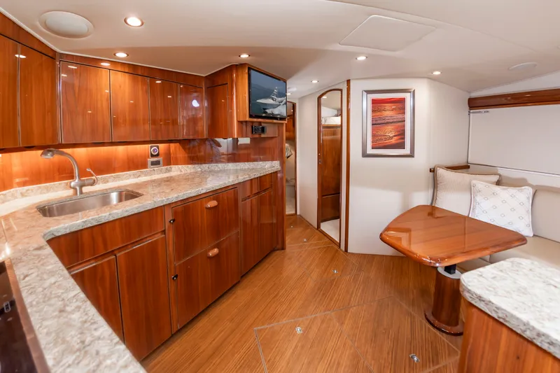 Slide: The Image of Interior of a luxury yacht with wooden cabinetry, a kitchenette, and a cozy dining area. - 25