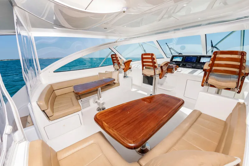 Slide: The Image of Interior of a luxury yacht with wooden tables and leather seating, surrounded by blue water. - 14