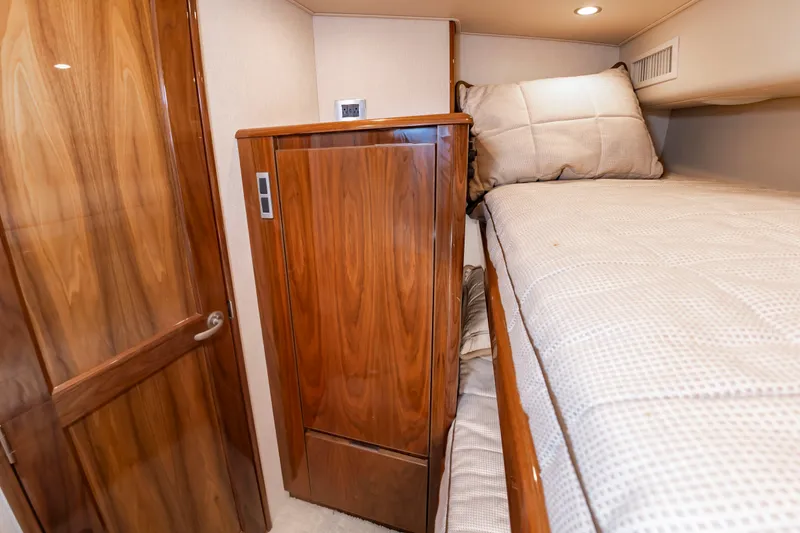 Slide: The Image of Interior of a yacht with wooden cabinets and a bunk bed with beige bedding. - 35