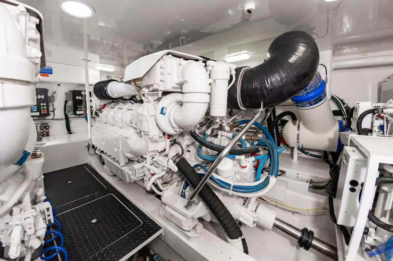 Slide: The Image of The engine room of a 2018 Viking Sport Tower with a large white engine and blue hoses. - 43