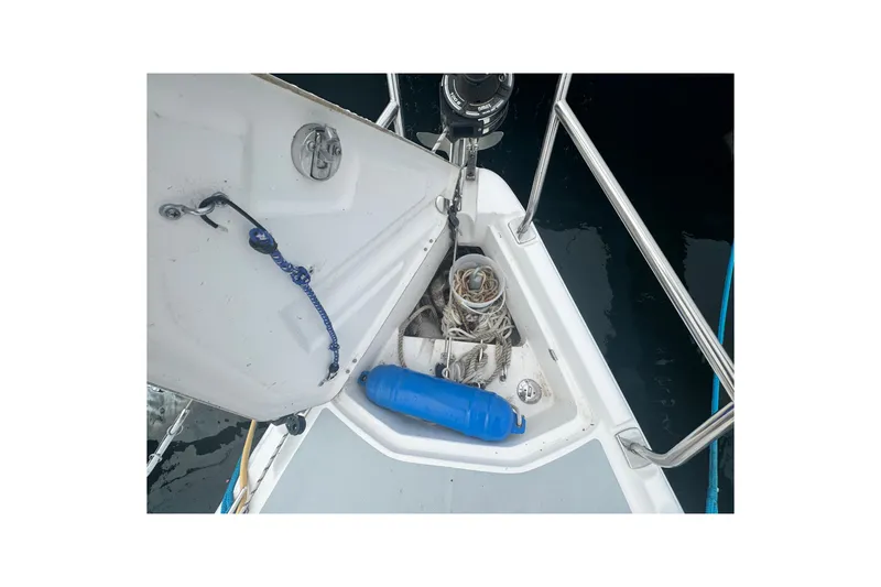 Slide: The Image of Open anchor locker on 2006 Hunter 31 sailboat with ropes and blue fender. - 14