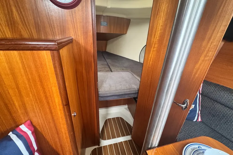Slide: The Image of Interior of a 2006 Hunter 31 sailboat with wood paneling and cozy sleeping area. - 32