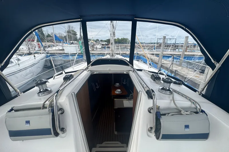 Slide: The Image of 2006 Hunter 31 sailboat cockpit with marina view, featuring winches and ropes. - 7