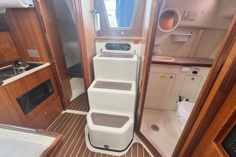 Slide: The Image of Interior of a 2006 Hunter 31 sailboat featuring a compact kitchen and bathroom. - 31