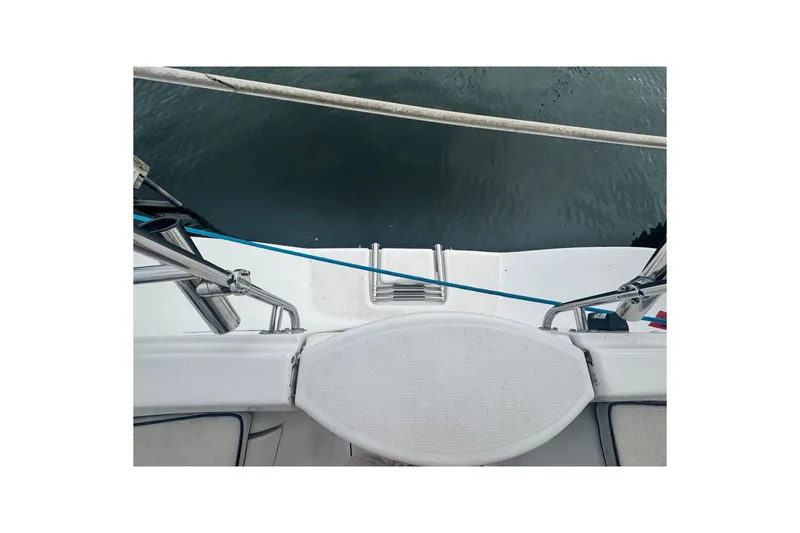 Slide: The Image of 2006 Hunter 31 sailboat stern view with railing and water backdrop. - 18