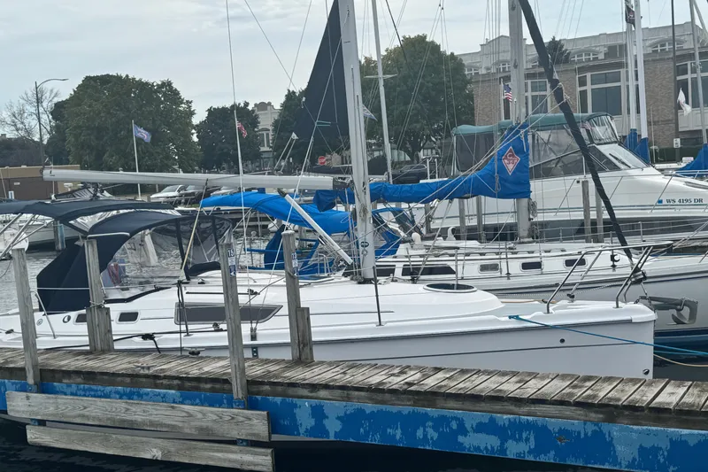Slide: The Image of 2006 Hunter 31 sailboat docked at a marina with other boats. - 2
