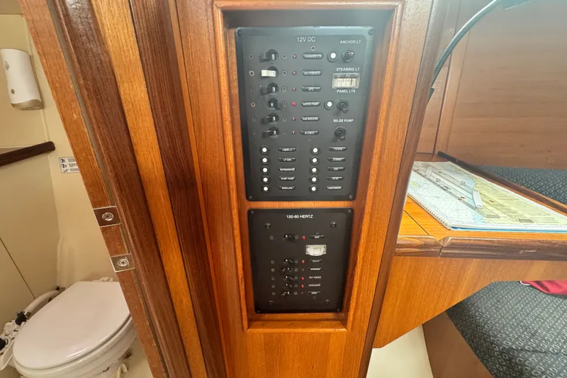 Slide: The Image of Electrical panel inside a 2006 Hunter 31 sailboat cabin, featuring switches and controls. - 20