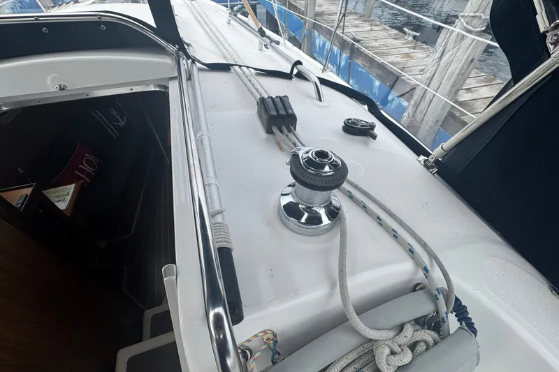 Slide: The Image of 2006 Hunter 31 sailboat deck with winch, ropes, and cabin entrance near dock. - 9