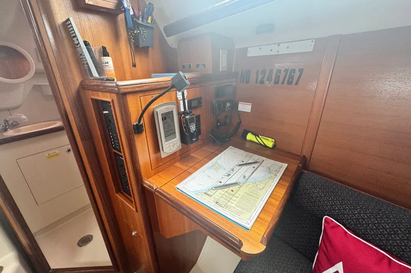 Slide: The Image of Navigation station inside a 2006 Hunter 31 sailboat with charts and instruments. - 21