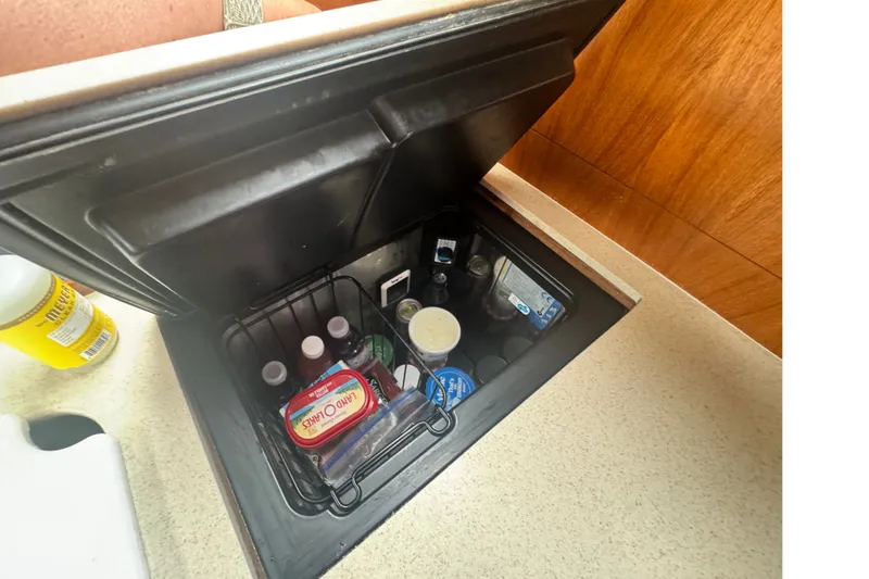 Slide: The Image of Storage compartment in a 2006 Hunter 31 yacht, containing various food and drink items. - 34