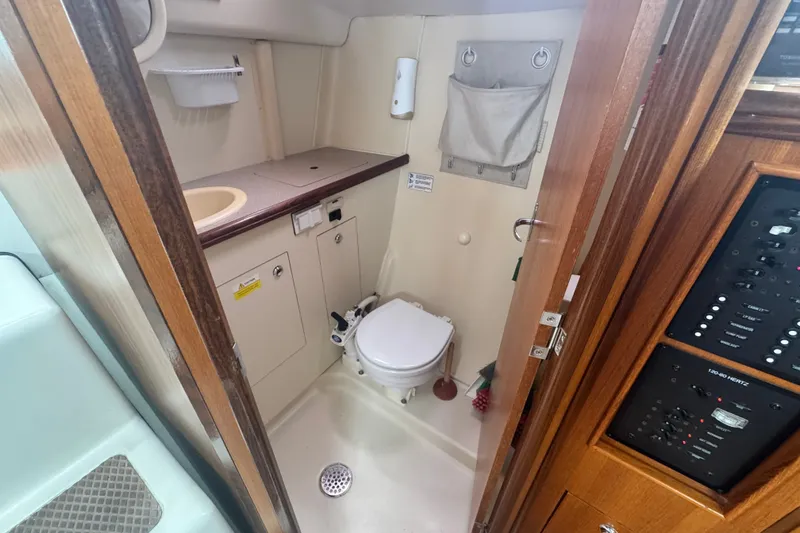 Slide: The Image of Compact bathroom in a 2006 Hunter 31 sailboat, featuring a toilet and sink. - 19