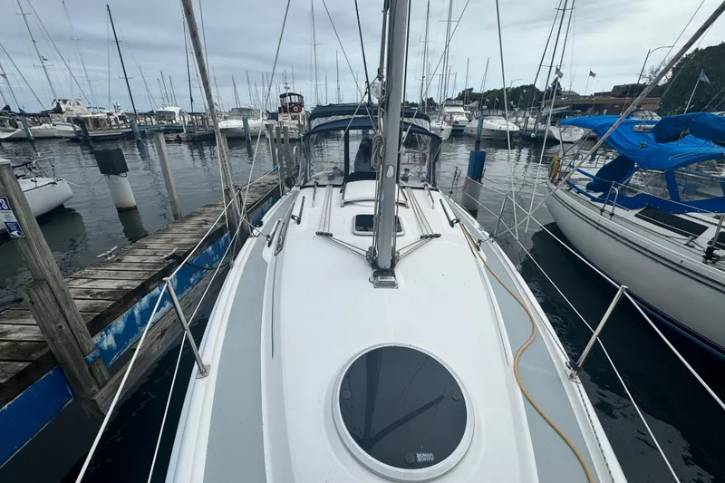 Slide: The Image of 2006 Hunter 31 sailboat docked at marina, surrounded by other boats. - 6