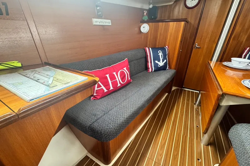 Slide: The Image of Interior of a 2006 Hunter 31 sailboat with nautical-themed cushions and wooden furnishings. - 23