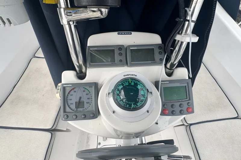 Slide: The Image of Cockpit instruments of a 2006 Hunter 31 sailboat, featuring compass and Raymarine displays. - 11