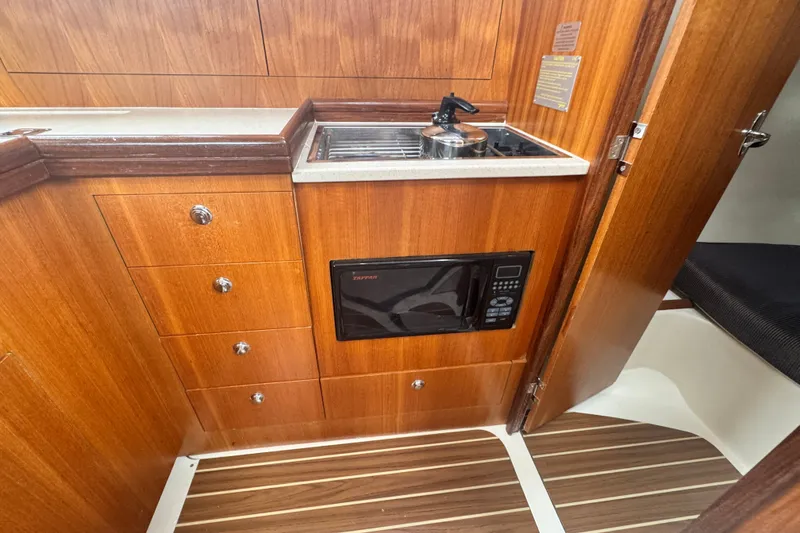 Slide: The Image of Wooden interior of a 2006 Hunter 31 yacht galley with stove and microwave. - 26