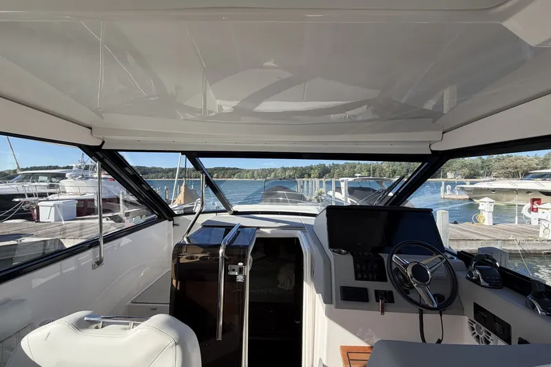 Slide: The Image of Interior view of 2022 Regal 36 Grande Coupe yacht cockpit with steering wheel and dashboard. - 19