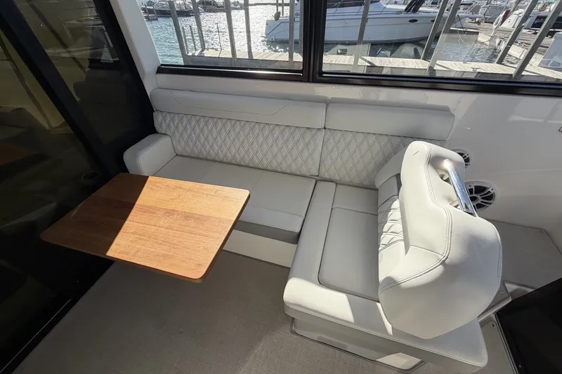 Slide: The Image of Interior seating area of 2022 Regal 36 Grande Coupe with wooden table and quilted upholstery. - 20