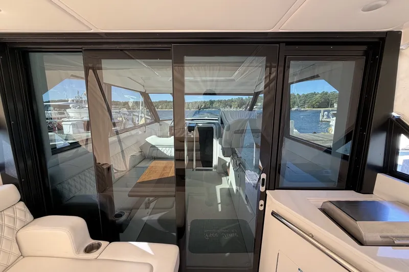 Slide: The Image of Interior view of 2022 Regal 36 Grande Coupe yacht with glass doors and luxurious seating. - 14