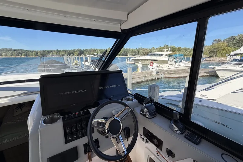 Slide: The Image of Interior view of 2022 Regal 36 Grande Coupe yacht cockpit with steering wheel and controls. - 22