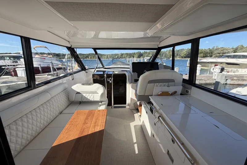 Slide: The Image of Interior of 2022 Regal 36 Grande Coupe yacht with elegant seating and scenic marina view. - 15