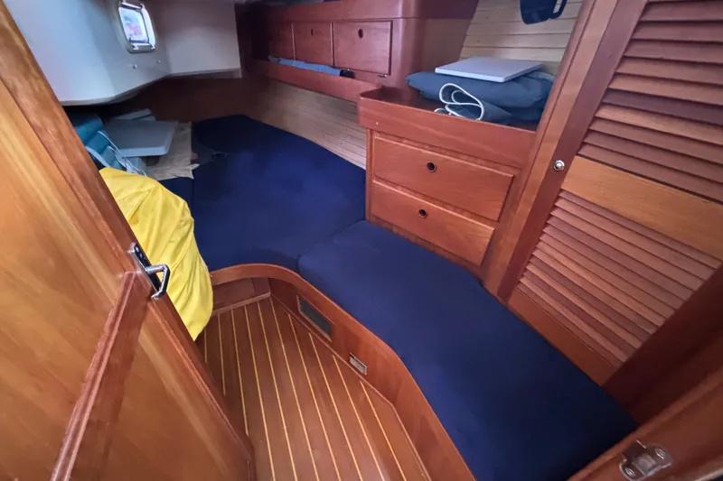 Slide: The Image of Cozy cabin interior of 2002 Sabre 402 sailboat with wooden furnishings and blue cushions. - 61