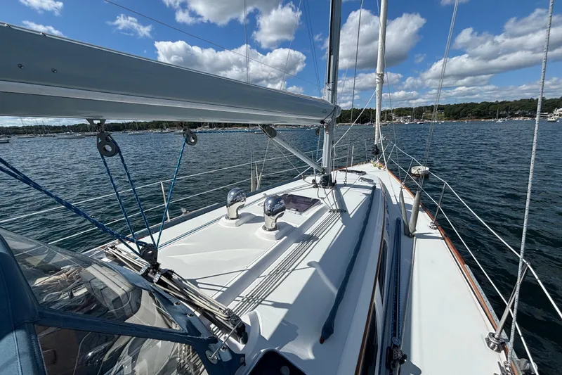 Slide: The Image of Sailing on a 2002 Sabre 402 yacht, calm waters, blue sky, and fluffy clouds. - 26