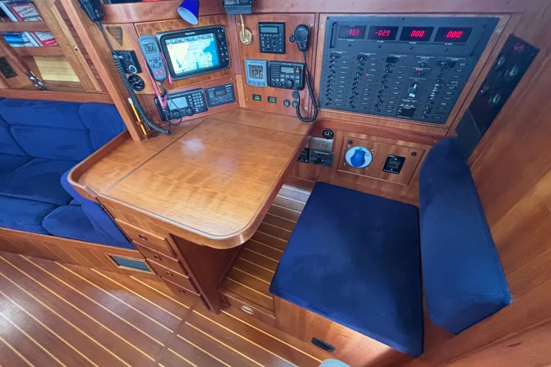 Slide: The Image of Navigation station in a 2002 Sabre 402 yacht with wooden interior and blue seating. - 35