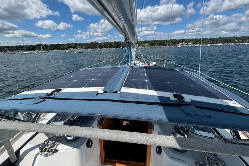 Slide: The Image of Sailboat Sabre 402 (2002) with solar panels on deck, anchored in a scenic harbor. - 24