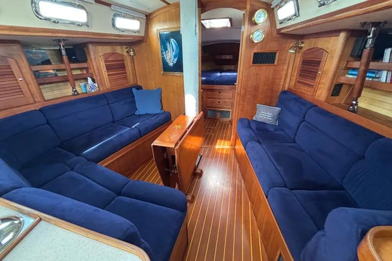 Slide: The Image of Luxurious 2002 Sabre 402 yacht interior with blue seating and wooden accents. - 49