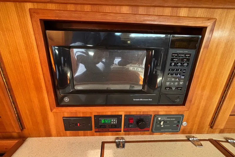 Slide: The Image of Built-in GE microwave in 2002 Sabre 402 yacht kitchen, surrounded by wood paneling. - 71