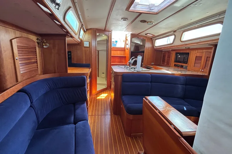 Slide: The Image of Luxurious 2002 Sabre 402 yacht interior with blue seating and wooden finishes. - 48