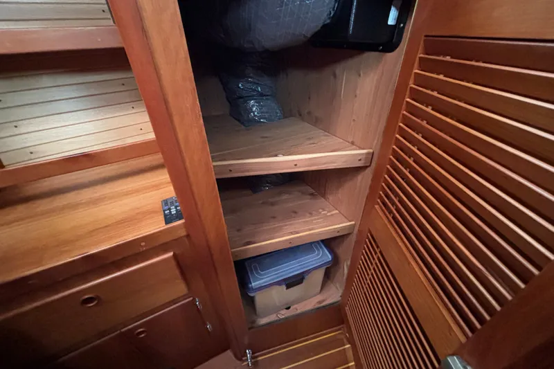 Slide: The Image of Wooden storage shelves inside a 2002 Sabre 402 boat, featuring organized compartments. - 60