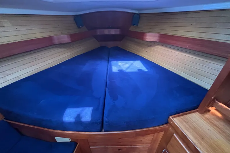 Slide: The Image of Interior cabin of a 2002 Sabre 402 yacht with blue cushions and wooden paneling. - 58