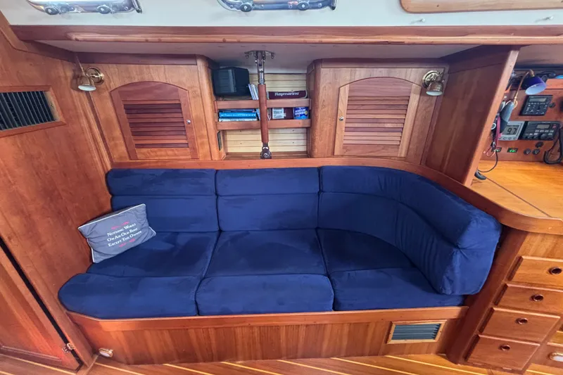 Slide: The Image of Luxurious 2002 Sabre 402 yacht interior with blue cushioned seating and wooden cabinetry. - 51