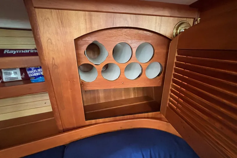 Slide: The Image of Wooden cabinet with circular storage spaces inside a 2002 Sabre 402 boat interior. - 54