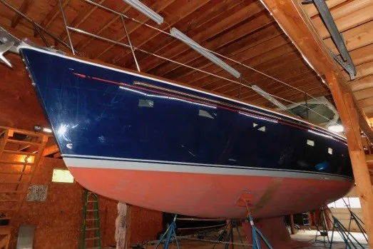 Slide: The Image of 2002 Sabre 402 sailboat in a wooden boathouse, supported by stands. - 86
