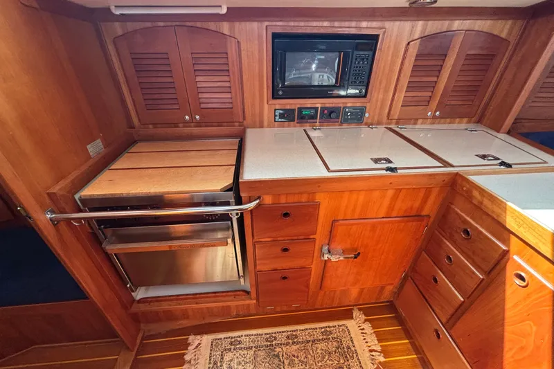 Slide: The Image of Wooden yacht galley with microwave, stove, and storage; Sabre 402, 2002 model. - 73