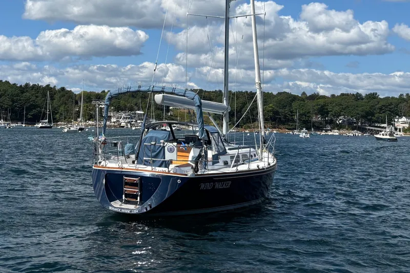 Slide: The Image of Sailing yacht Sabre 402, 2002 model, anchored in scenic harbor with cloudy sky. - 13
