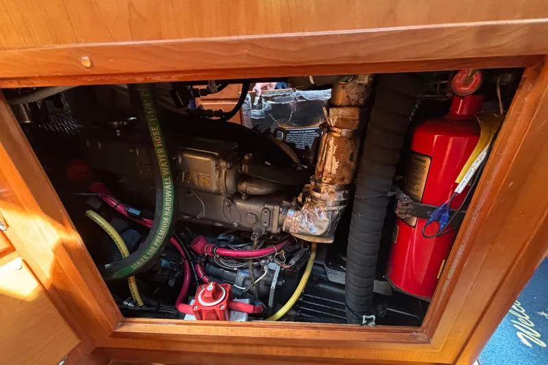 Slide: The Image of Engine compartment of a 2002 Sabre 402 boat, featuring hoses and a fire extinguisher. - 77