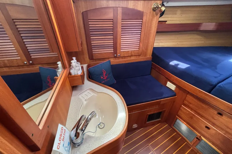 Slide: The Image of Luxurious 2002 Sabre 402 yacht cabin with wooden interior, cozy seating, and elegant sink area. - 57