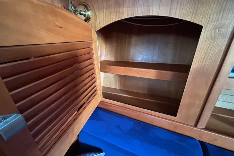 Slide: The Image of Wooden interior cabinet with open louvered door in a 2002 Sabre 402 yacht. - 55